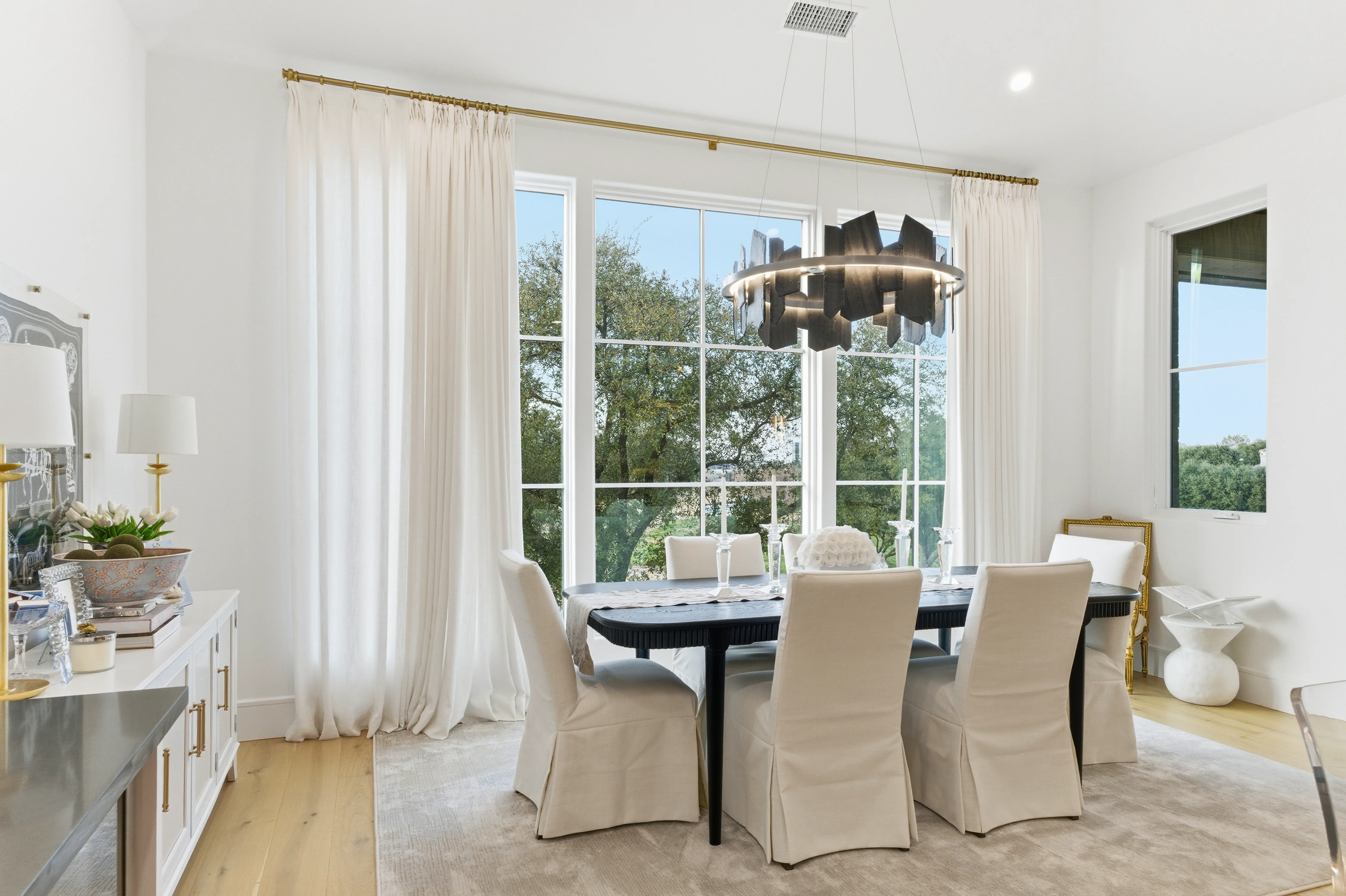 Dining room with designer chandelier and floor-to-ceiling windows