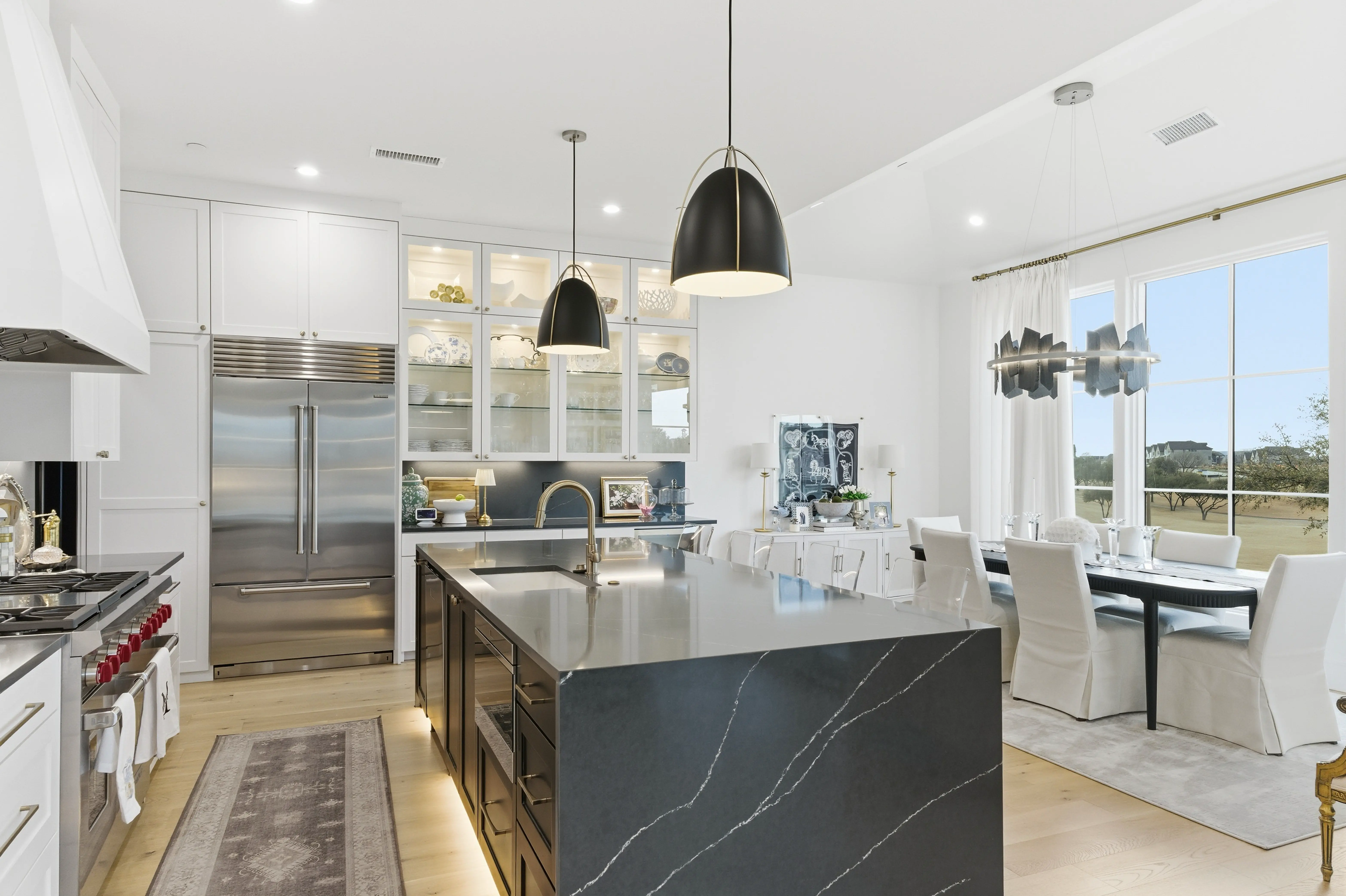 Kitchen with Sub-Zero refrigerator, glass-front cabinetry, and dining nook