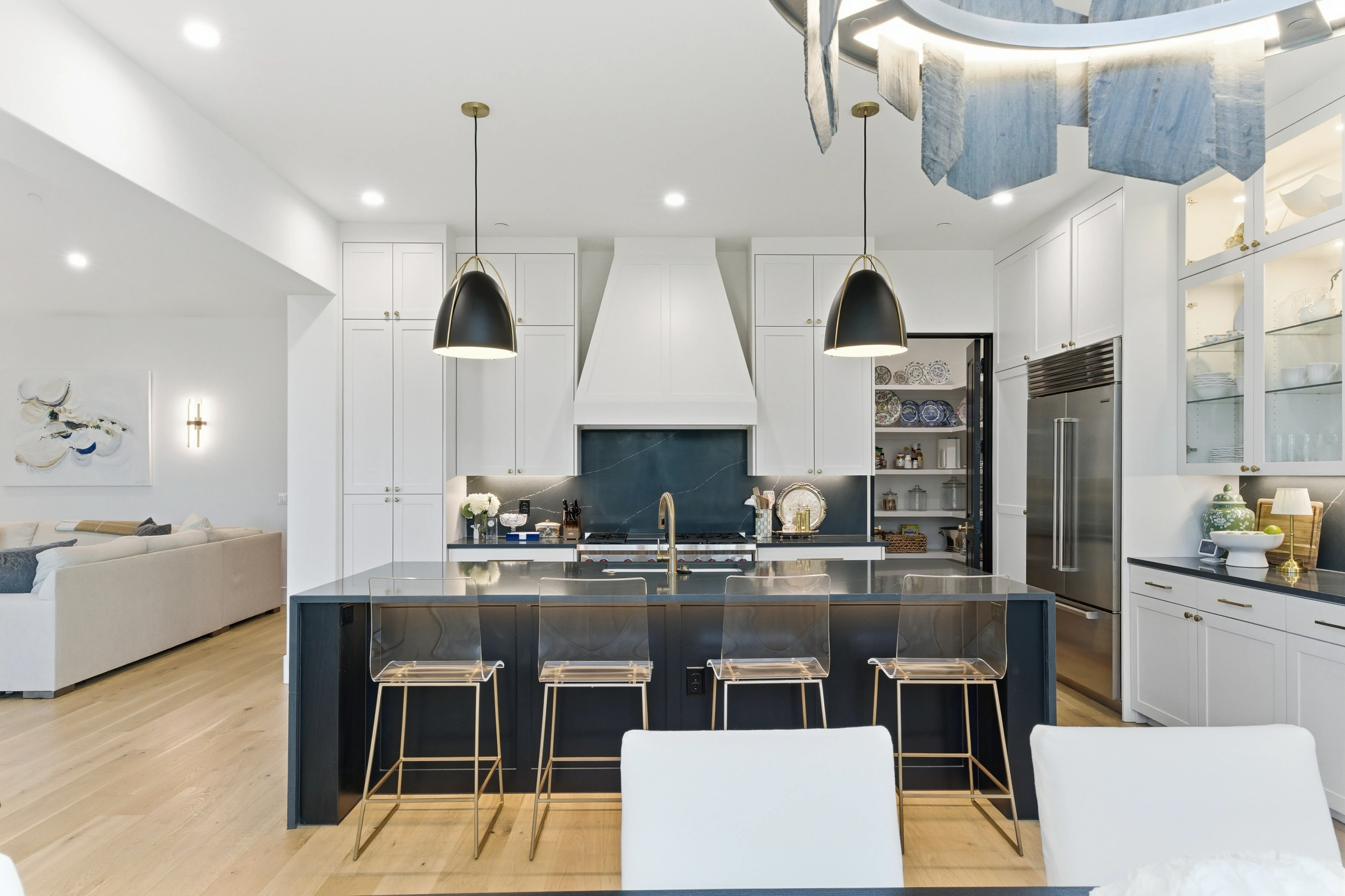 Designer kitchen with dark stone island, pendant lighting, and professional appliances