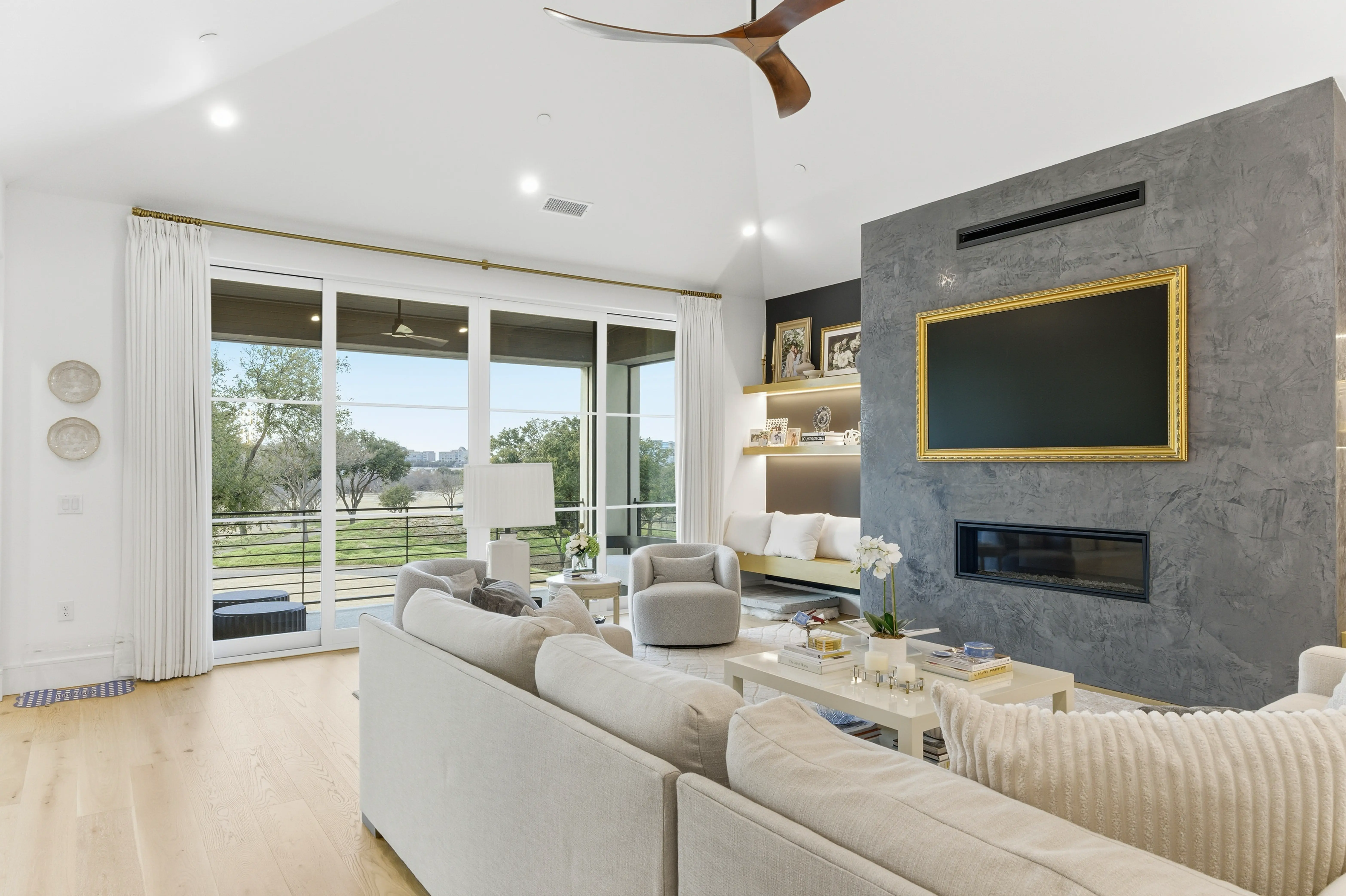 Living room with linear fireplace, stone accent wall, and balcony access