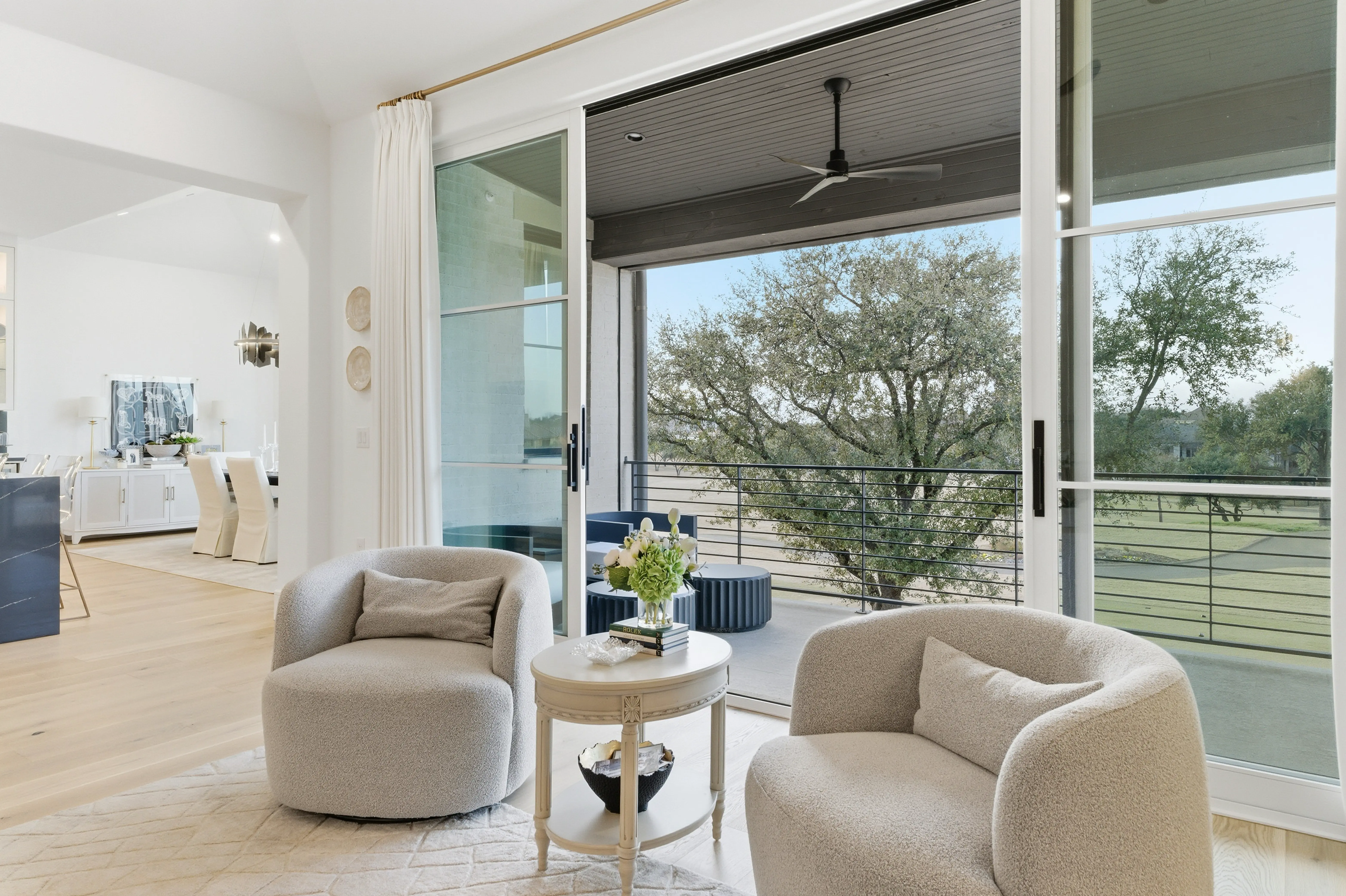 Sitting area opening to covered balcony with golf course views