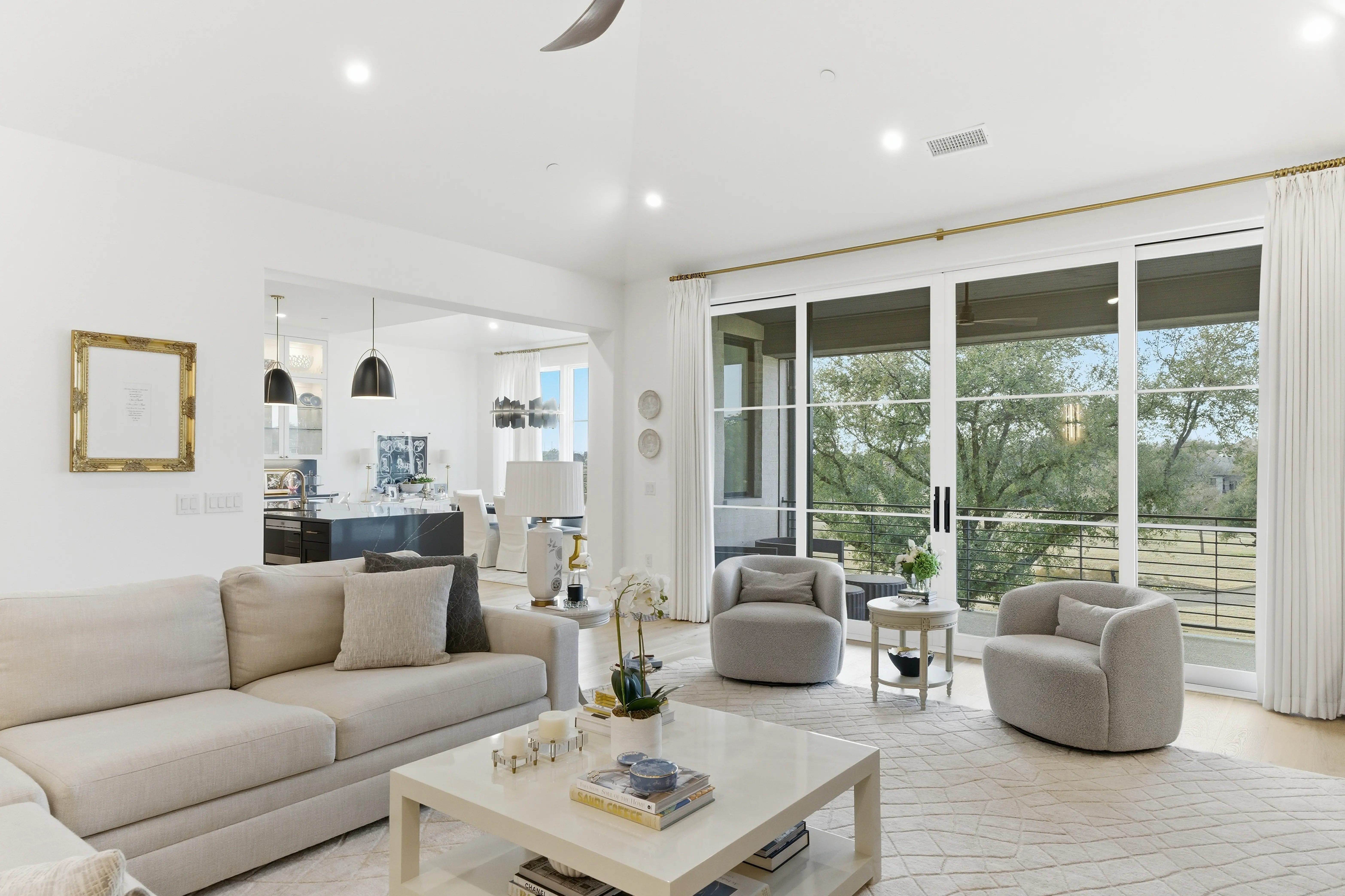 Open living room flowing into designer kitchen with golf course views