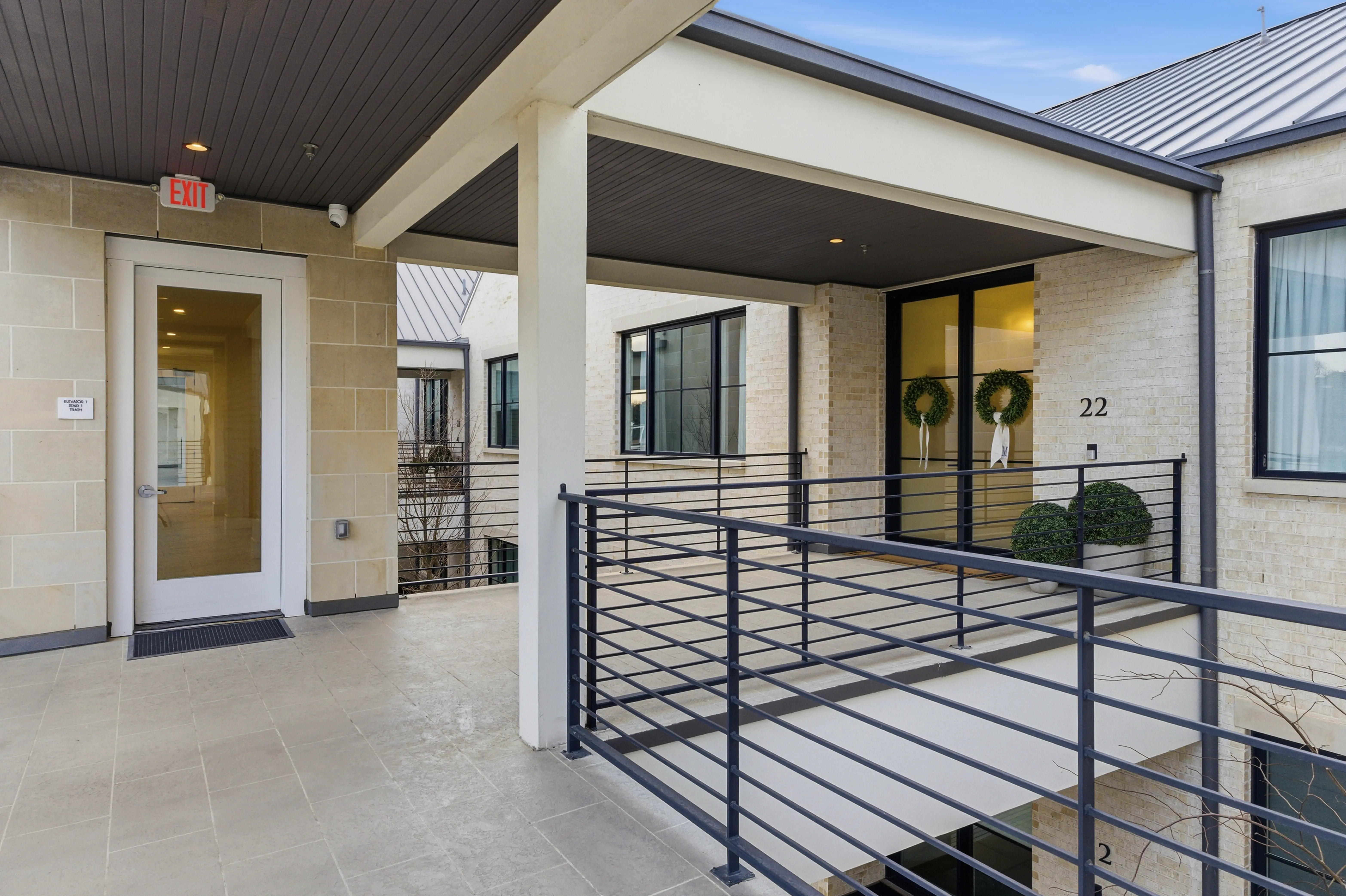 Covered walkway and building exterior with limestone and metal roof
