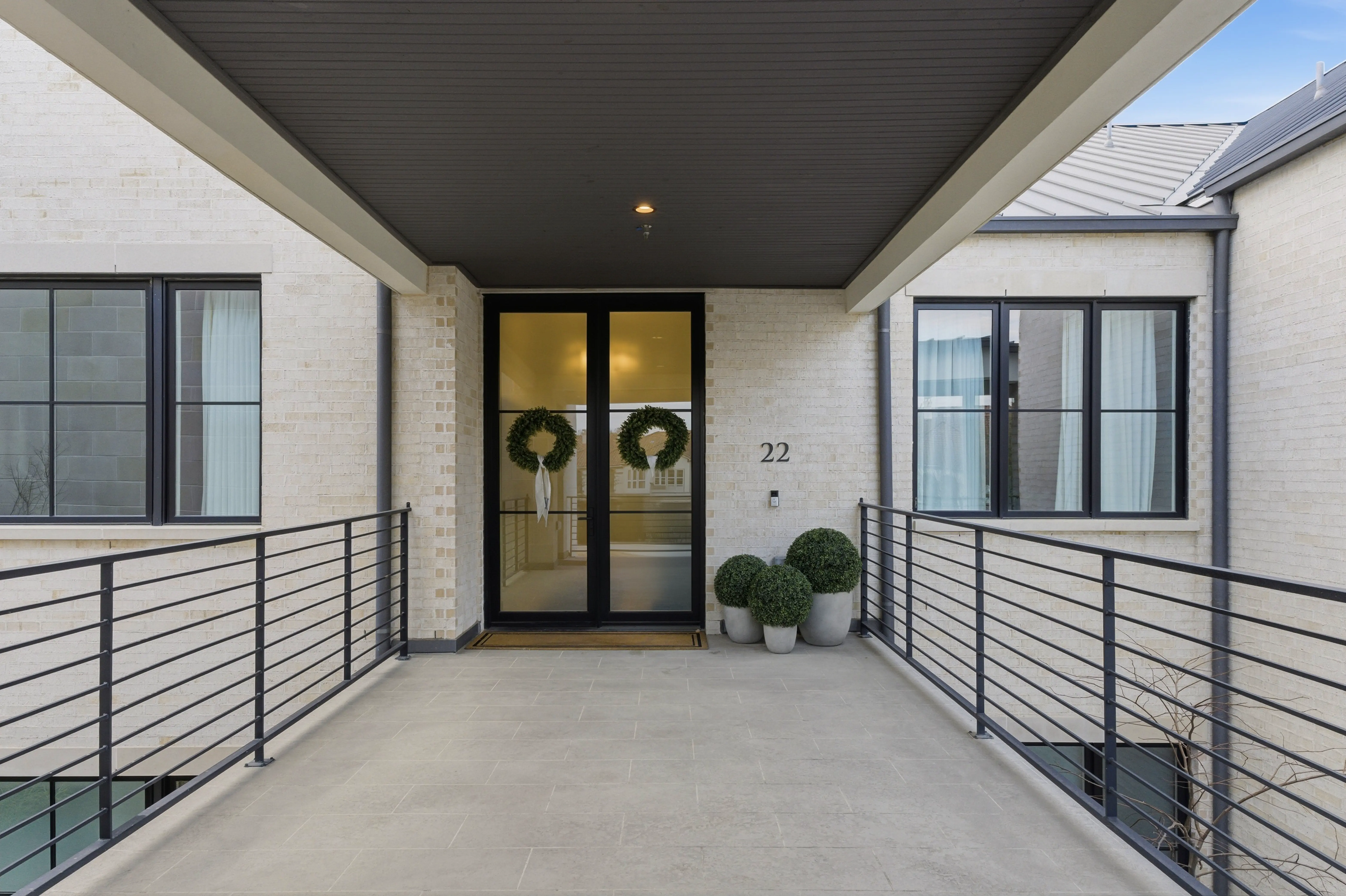 Private covered entry with limestone facade and black iron railings